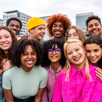 Happy playful multiethnic group of young friends bonding outdoor